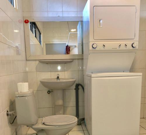 a small bathroom with a toilet and a sink at Tropical Breeze Apartments in Paramaribo