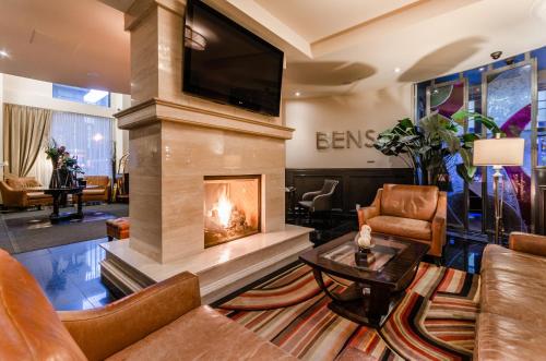 a living room with a fireplace and a tv at Le St-Martin Hotel Centre-ville – Hotel Particulier in Montréal