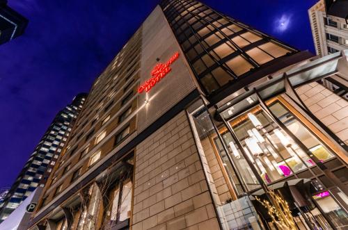 a building with a red sign on the side of it at Le St-Martin Hotel Centre-ville – Hotel Particulier in Montréal