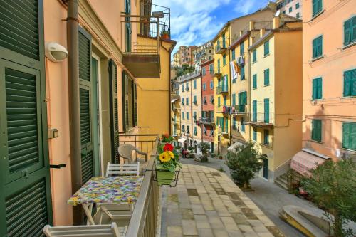 a balcony with a table and flowers on a street at Da Elisa in Riomaggiore