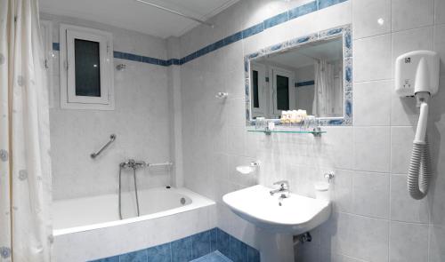 a bathroom with a sink and a bath tub and a sink at Alex Hotel in Tripolis