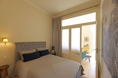 1 dormitorio con 1 cama y puerta corredera de cristal en FLH Almada Cozy Apartment with View, en Oporto