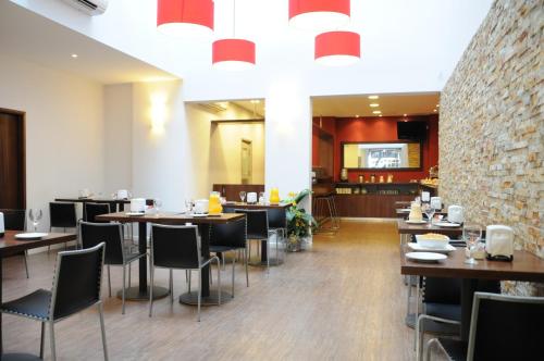 a restaurant with tables and chairs and a brick wall at Hotel California in Montevideo