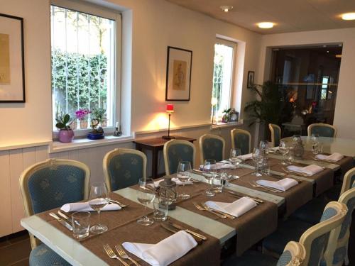 een eetkamer met een tafel en stoelen met wijnglazen bij Piccolo Hotel in Locarno