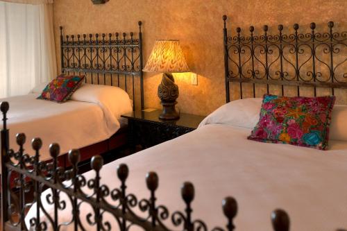 a hotel room with two beds and two lamps at Hotel Atitlan in Panajachel