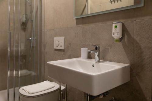a bathroom with a sink and a toilet and a shower at San Martino Rooms in Pula