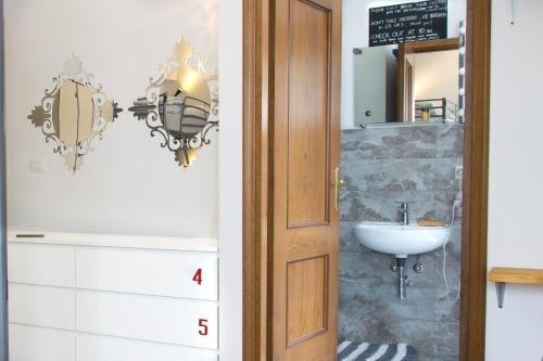 un baño con lavabo y espejo en Posada Verona Hostel, en Verona