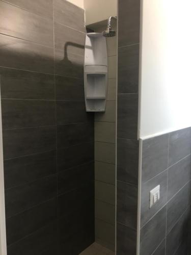 łazienka z czarną ścianą wyłożoną kafelkami w obiekcie Cheap Stop w mieście Pompeje