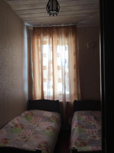 a bedroom with a bed and a window with a curtain at Sweet home in Lalkhori