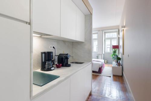 a kitchen with white cabinets and a sink at Domus 21 - Formosa in Porto