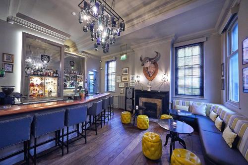 a bar with blue chairs and a fireplace at Hotel du Vin Winchester in Winchester