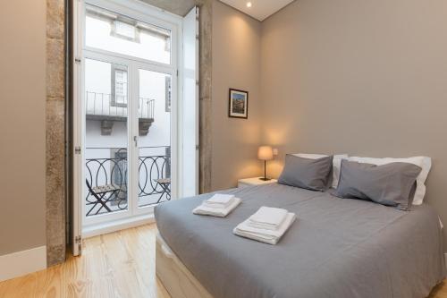 ポルトにあるPorto and Clérigos Views by Porto City Hostsのベッドルーム1室(大型ベッド1台、タオル2枚付)