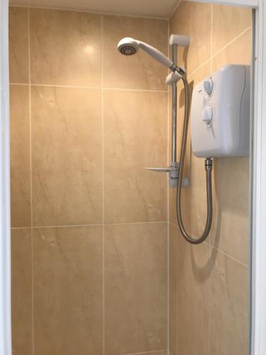 a shower with a shower head in a bathroom at Trevellis Bed and Breakfast in Newquay