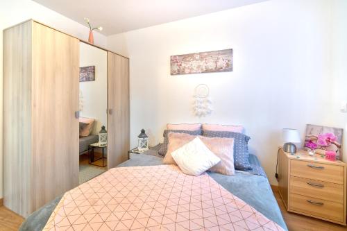 een slaapkamer met een bed met roze en blauwe lakens bij Gîte Figues et Caraïbes in Cers