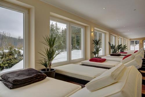 una fila di letti in una stanza con finestre di Wellnesshotel deine Auszeit, Adults only ad Achslach