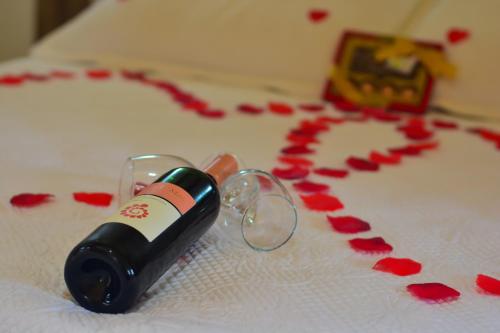 a bottle of wine on a table with red roses at Pousada Varanda Colibri in Monte Verde