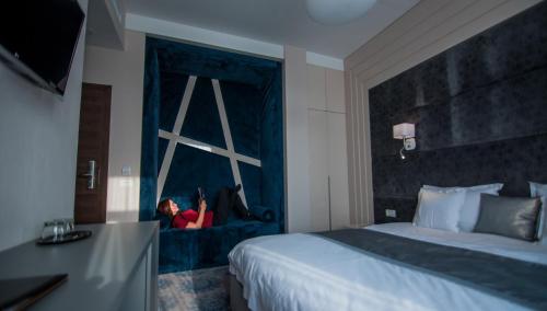 a woman sitting on a window seat in a hotel room at Element in Alba Iulia