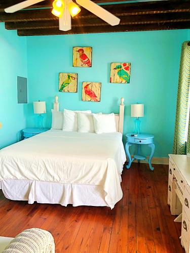 a bedroom with a large white bed with blue walls at Creole Gardens Guesthouse and Inn in New Orleans
