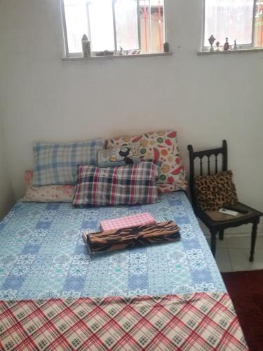 um quarto com uma cama com um cobertor e travesseiros em Se hospede num Cantinho Gourmet em Salvador