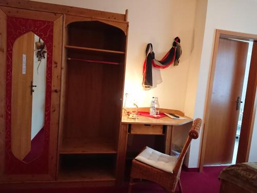 a bedroom with a desk and a dresser and a closet at Hotel & Ferienwohnungen Bohlenblick in Saalfeld