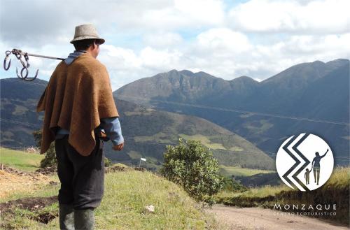 a man standing on a hill looking at the mountains at Monzaque- paraíso de bachué in El Barrial