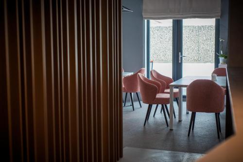 a dining room with pink chairs and a table at Element in Alba Iulia