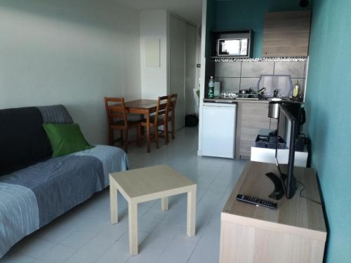 un salon avec un canapé et une table et une cuisine dans l'établissement 483 Chemin de Saint-Clair, à Sète