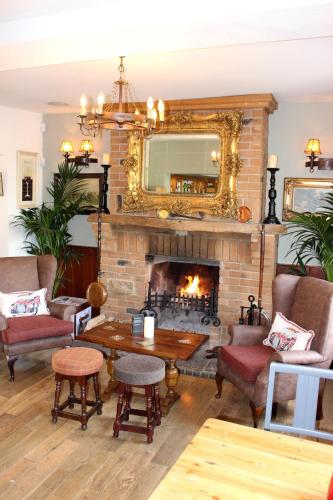 a living room with a fireplace and a mirror at The Coach and Horses in Worthing