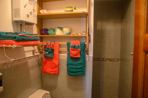 a bathroom with four towels hanging on a rack at King Lewey's Island Resort in Placencia Village