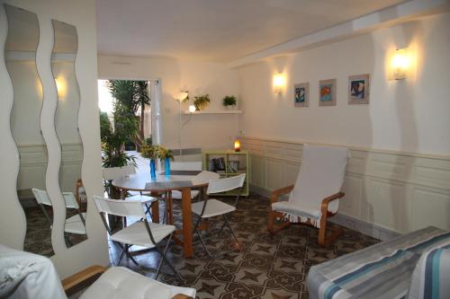 a living room with a table and white chairs at Villa sainte claire in Amélie-les-Bains-Palalda