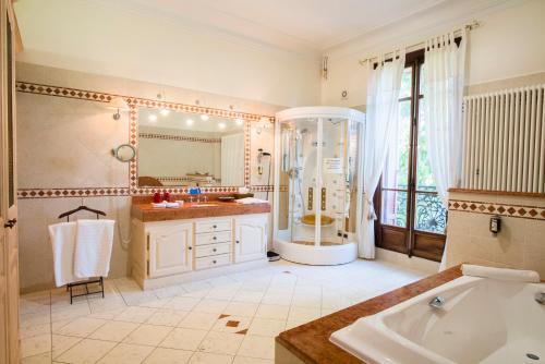 a bathroom with a tub and a large mirror at Villa Morelia in Jausiers