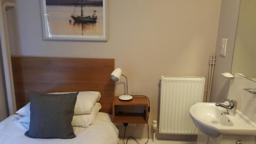 ein Schlafzimmer mit einem Bett, einem Waschbecken und einer Lampe in der Unterkunft The York Hotel in Weston-super-Mare