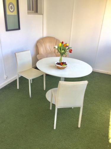 a white table and two chairs and a table with flowers at Hotel Excelsior in Lisbon