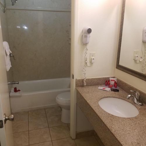 a bathroom with a sink and a toilet and a phone at SureStay Hotel by Best Western Hollister in Hollister