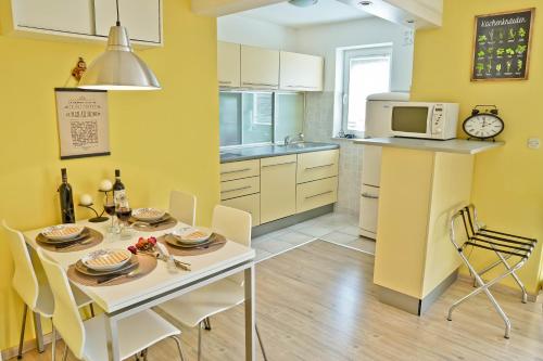 a kitchen with a table and chairs and a microwave at Josephine Rabac in Rabac