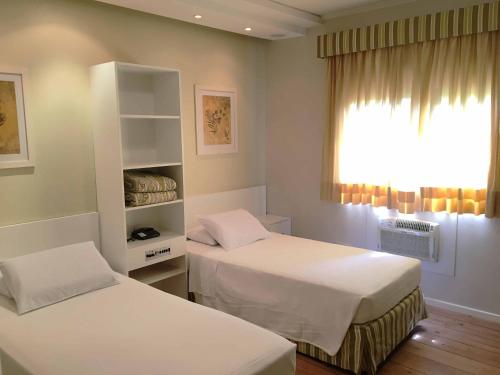 a hospital room with two beds and a window at Cosmos Hotel in Caxias do Sul