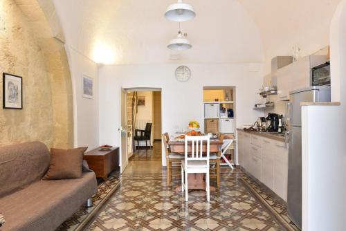un salon avec un canapé et une table dans une cuisine dans l'établissement L'eco dei sassi, à Matera