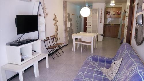 sala de estar con sofá, TV y mesa en TOSSA MEDIEVO, apartamento a 150 m de la playa, en Tossa de Mar