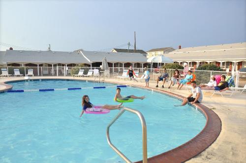 um grupo de pessoas brincando em uma piscina em Cavalier by the Sea em Kill Devil Hills