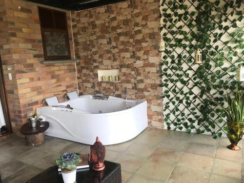 a bath tub in a room with a brick wall at Hotel Tata Premium in Pueblo Tapao