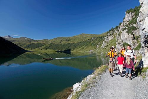a group of people walking down a path next to a lake at Haus am Lift in Kleinarl