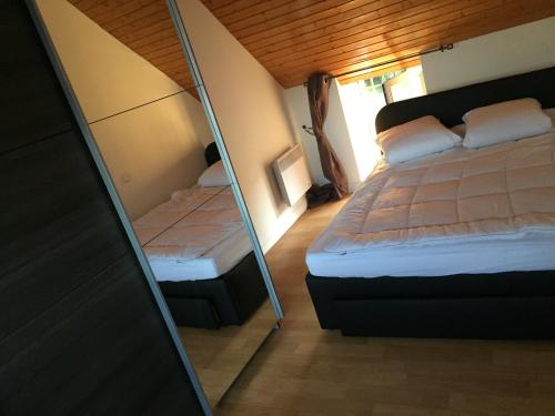 1 dormitorio con cama y espejo en Gîte Callac Plumelec P 9, en Plumelec