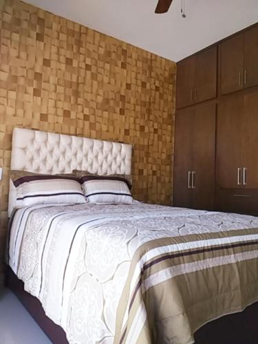 ein Schlafzimmer mit einem großen Bett mit weißer Bettwäsche und Kissen in der Unterkunft RENTA VACACIONAL A 2 CUADRAS DE LA PLAYA O MALECON DE MAZATLAN in Mazatlán