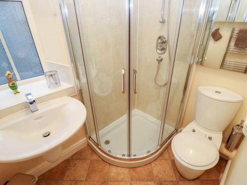 uma casa de banho com um chuveiro, um WC e um lavatório. em The River Appartment em Todmorden