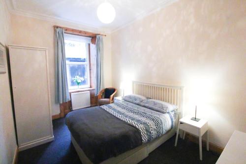 a bedroom with a bed and a window at Oban Town Centre Apartment in Oban