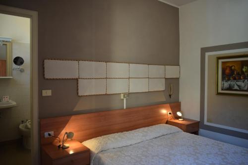 a bedroom with a large bed and two lights on the wall at Albergo Al Pescatore in Brenzone sul Garda