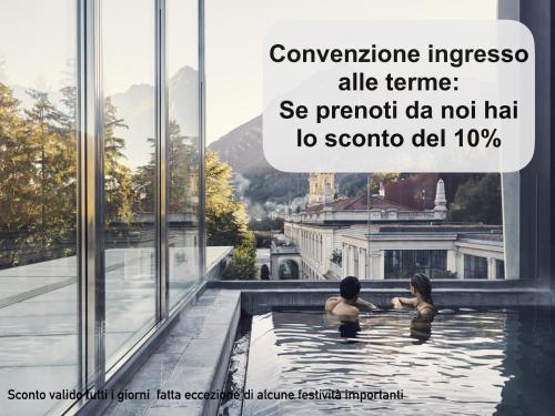 two people in a swimming pool in a building at Design Suite Cavagna in San Pellegrino Terme