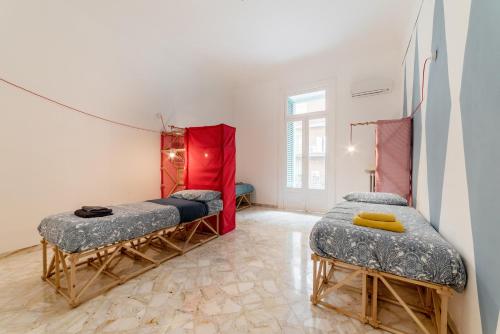 a room with two beds and a red curtain at Macchia Mediterranea Guest House in Bari