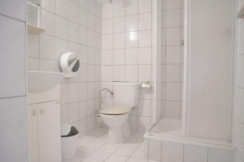 a white bathroom with a toilet and a shower at Pensjonat i Restauracja U Zdzicha in Rowy