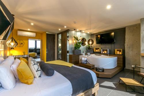 a bedroom with a large bed and a bath tub at Epic Boutique Hotel in Medellín